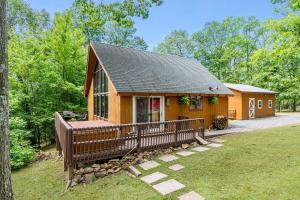 a cabin in the woods with a deck and a house at Quaint Cabin w Hot Tub Firepit & Deck in Hedgesville