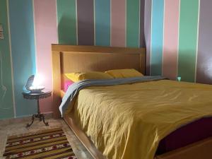 1 dormitorio con cama y pared a rayas en "Pearl in Middle Atlas", en Azrou