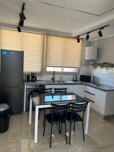 a kitchen with a table and chairs and a refrigerator at Luxury Rooftop WiFi, AC, BBQ in Rejiche