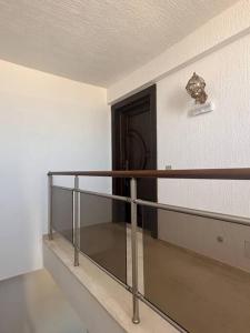 een balkon met een leuning en een deur in een kamer bij Luxury Rooftop WiFi, AC, BBQ in Rejiche