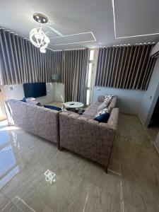 een woonkamer met een grote bank in een kamer bij Luxury Rooftop WiFi, AC, BBQ in Rejiche