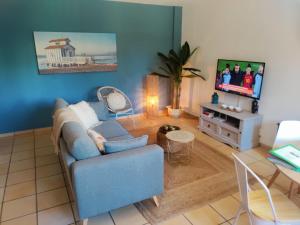 sala de estar con sofá azul y TV en Casa Cariño @ Hacienda del Alamo Golf resort, en Fuente Alamo
