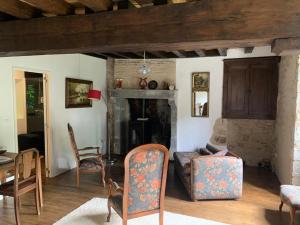 uma sala de estar com cadeiras e uma lareira em Moulin de chez Joyeux em Thiat