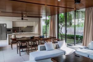 an open kitchen and living room with white furniture at Naman Retreat in Da Nang