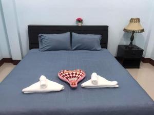 a bed with a pair of shoes and a pair of slippers at หม่อนเมือง รีสอร์ท in Chiang Rai
