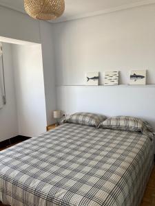 1 dormitorio con 1 cama con manta a cuadros en Apartamento en Sada en primera línea de playa, en Sada
