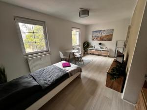a bedroom with a bed and a table and two windows at Ferienwohnung Sonntag, Elsteraue in Elsteraue +2 photos