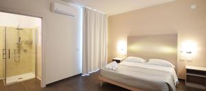 トリーノ・ディ・サングロにあるHotel La Siestaのベッドとシャワー付きのホテルルーム
