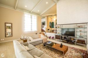 a large living room with a couch and a tv at Casa de Campo in Atibaia