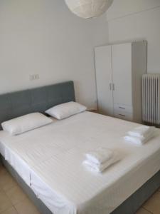 duże białe łóżko z 2 białymi poduszkami w obiekcie Glyfada First Center w Atenach
