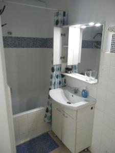 ein Badezimmer mit einem Waschbecken und einer Badewanne in der Unterkunft Glyfada First Center in Athen
