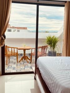 een slaapkamer met een bed en uitzicht op de oceaan bij Maison Khoi Homestay in Hội An