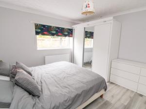 a white bedroom with a bed and a window at 10 Southcliffe Drive in Filey