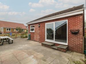 a brick building with a large window next to a picnic table at 10 Southcliffe Drive in Filey