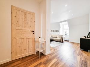- un salon avec une porte en bois et un canapé dans l'établissement Apartament Pod Siódemka, à Jelenia Góra