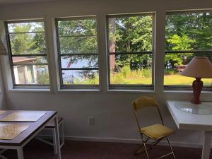 a room with a desk and a chair and windows at Cozy Lakefront with Beach of your own! in Franklin