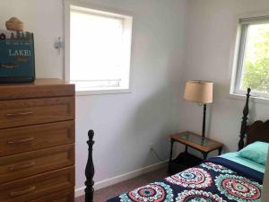 a bedroom with a bed and a dresser and a window at Cozy Lakefront with Beach of your own! in Franklin
