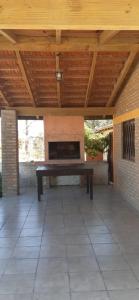 un patio con un banco bajo un techo de madera en Casas HG - Cabañas sencillas y cómodas en las Sierras - Ideal para trabajar - Cochera - Aceptamos mascotas en Huerta Grande