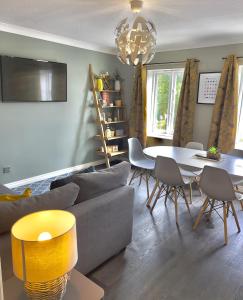 een woonkamer met een bank, een tafel en stoelen bij Monkbridge Mews Apartment in York +8 foto's