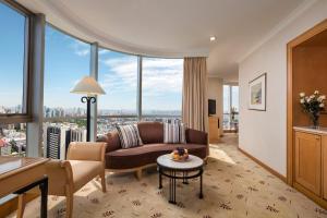 uma sala de estar com um sofá e uma mesa em Sheraton Nanjing Kingsley Hotel & Towers em Nanquim