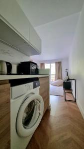 uma cozinha com uma máquina de lavar roupa num quarto em Cosy Studio near Monaco SEA VIEW Balcony em Beausoleil