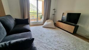uma sala de estar com um sofá e uma televisão de ecrã plano em Cosy Studio near Monaco SEA VIEW Balcony em Beausoleil