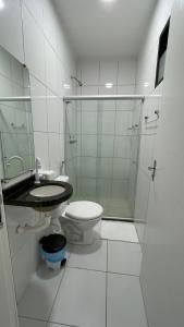 a bathroom with a toilet and a glass shower at Falcão Hotel Arapiraca in Arapiraca