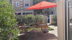 stół i krzesła pod parasolem na patio w obiekcie La Villa Mandarine sur Arcachon w Arcachon
