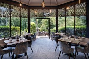 a restaurant with tables and chairs and large windows at Delta Hotels by Marriott Swindon in Swindon