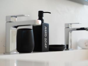 une bouteille noire de savon assise sur une étagère dans l'établissement Le Terrazze, à Venise