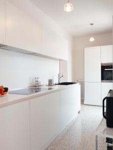 uma cozinha branca com armários e electrodomésticos brancos em Le Terrazze em Veneza
