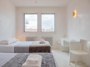 a white bedroom with a bed and a desk at Le Terrazze in Venice
