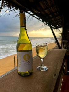 uma garrafa de vinho e um copo sobre uma mesa em Indika Beach Villa em Galle