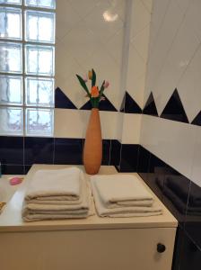 una mesa con toallas y un jarrón con flores. en Residenza Del Sole, en Surbo