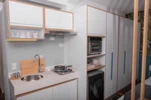 uma pequena cozinha com armários brancos e um lavatório em 5Q House Quinta Camacho em Bogotá