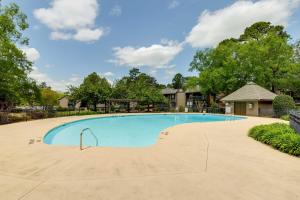 a large swimming pool at a resort with trees at Lakeview Condo with Resort Pool 2 Miles to Golf! in Pinehurst