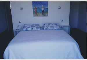 Un dormitorio con una cama blanca y una pintura en la pared en TAKAMAKA, en Manosque