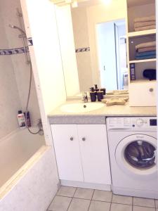 a bathroom with a sink and a washing machine at OLYMPE in Saint-Denis