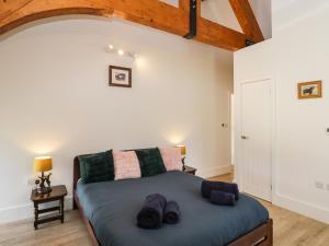 a bedroom with a bed with shoes on it at The Old Barn in Witney