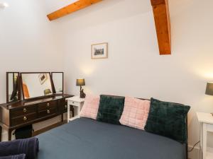a bedroom with a bed and a dresser and a mirror at The Old Barn in Witney