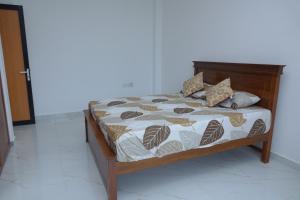 1 dormitorio con cama con marco de madera y cama sidx sidx sidx en LAYENSA, en Gampaha