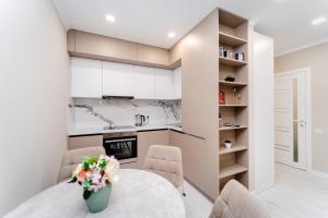 a kitchen and dining room with a table and chairs at 2-Bedroom Family Grandeur Apartment in Chişinău