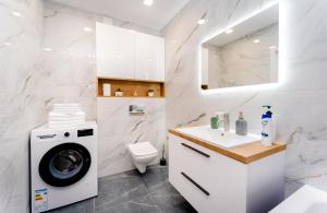 a bathroom with a washing machine and a washer and dryer at 2-Bedroom Family Grandeur Apartment in Chişinău