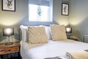 een slaapkamer met een bed met witte lakens en 2 lampen bij Plush Nest - Charming One-Bedroom Flat - Southend Stays in Southend-on-Sea
