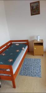 een kleine slaapkamer met een bed en een tafel bij Visszavár-Lak privát bérlemény in Badacsonytomaj