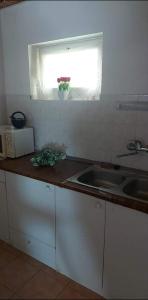 a small kitchen with a sink and a window at Visszavár-Lak privát bérlemény in Badacsonytomaj