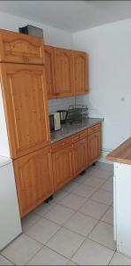 a kitchen with wooden cabinets and a counter top at Visszavár-Lak privát bérlemény in Badacsonytomaj