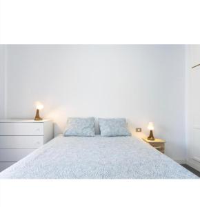 una camera bianca con un letto e due lampade di COCO apartament. a El Médano