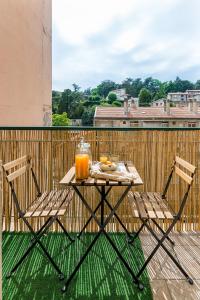 サン・テティエンヌにあるAPPART COSY - COMME À LA MAISON - ST ETIENNEのテーブル(椅子2脚付)、バルコニー(オレンジジュース付)