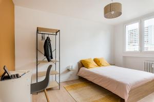 サン・テティエンヌにあるAPPART COSY - COMME À LA MAISON - ST ETIENNEのベッドとパソコン付きの机がある寝室